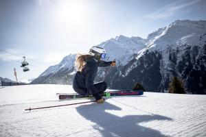 圣安东阿尔贝格Quality Hosts Arlberg - AFOCH FEI - das Landhaus的一位妇女坐在雪覆盖的滑雪场上