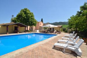 德鲁塔Villa Santa Maria Deruta的一个带躺椅的游泳池以及一座房子