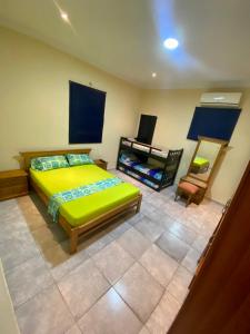 巴兰基亚La Casona 42的一间卧室配有绿色的床和椅子