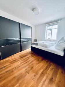 不莱梅Mi Casa 3 Zimmer geschmackvoll zentral in Bremen的一间卧室配有一张床,铺有木地板