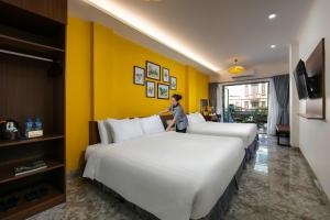 河内Hanoi La Cascada House & Travel的站在酒店房间两张床之间的女人