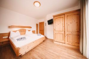 斯拉德明Posers Bergwelt的一间卧室配有一张床和一个大型木制橱柜
