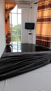 卡图纳耶克Air Vision 98的一间卧室设有一张带电视和窗户的床。