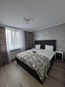 LupeniDelux Flat Straja-Lupeni的一间卧室设有一张大床和一个窗户。