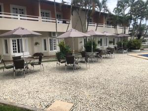 瓜拉派瑞瓜拉派瑞诺瓦酒店的大楼前方设有带桌椅和遮阳伞的天井。