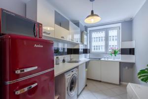 华沙ClickTheFlat Żurawia Street Apart Rooms的厨房配有红色冰箱和洗衣机