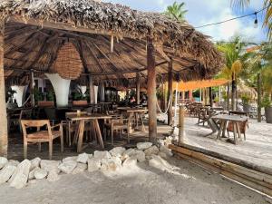 Dorp Sint MichielTip! Blue Bay Beachvilla 12 - Blue Bay Resort的一间带桌椅和稻草伞的餐厅