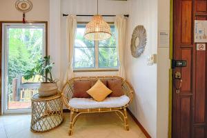 高兰Villa Siam Lanna at Kantiang Bay的带柳条椅和窗户的客房