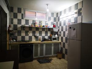 纳布卢斯YCC Guesthouse的厨房设有黑白瓷砖墙壁和冰箱。