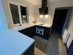 金斯林Harewood Lodge - Single and Double Rooms Self Serve Apartment的一间带两个盥洗盆的浴室和一台电视。