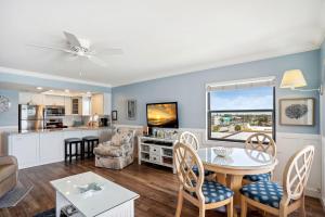 圣徒皮特海滩Emerald Isle 401 - Premier的一间带桌椅的客厅和一间厨房