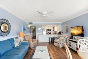 圣徒皮特海滩Emerald Isle 401 - Premier的一间带蓝色沙发的客厅和一间厨房