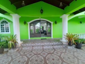 Bon AccordPESHERES INN & SPA的绿色的客房设有门和盆栽植物