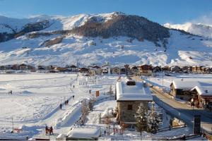 利维尼奥Hotel Bondi的雪中的一个小镇,背景是山