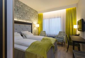 奥斯陆松恩会议酒店的酒店客房设有一张大床和一张书桌。
