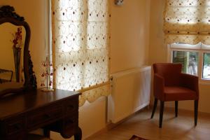 卡斯托里亚Room in Faneromeni's grove的一间带椅子、梳妆台和窗户的房间