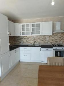 博德鲁姆Ferienhaus mit Meerblick的白色的厨房配有白色橱柜和水槽