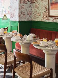 巴黎Hôtel Les Deux Gares的用餐室设有2张桌子,并配上餐具