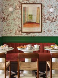 巴黎Hôtel Les Deux Gares的一间用餐室,配有两张带食物盘的桌子