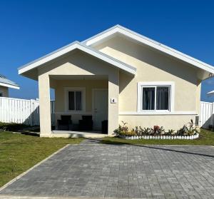 卢西Seamist villa @Oceanpointe Lucea comfy 2BR w/pool gym & parking的白色围栏的小房子
