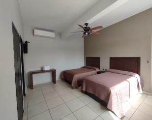 阿瓜斯卡连特斯HOTEL SAN MARCOS的一间卧室配有两张床和吊扇
