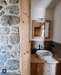 Zambla AltaAtelier della Montagna的一间带水槽和石墙的浴室