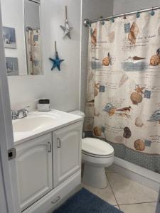 可可比奇Bright and Beachy 2Bed 1Bath Home - Unit 210的浴室配有水槽、卫生间和浴帘