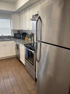 可可比奇Beautiful Bright & Sparkling 2Bed 1Bath Beach Retreat - Unit 212的一间厨房内的不锈钢冰箱,厨房内有白色的橱柜