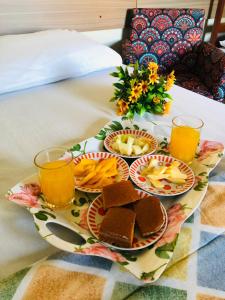 伊瓜苏POUSADA EVELINA的床上的食品托盘,配上橙汁