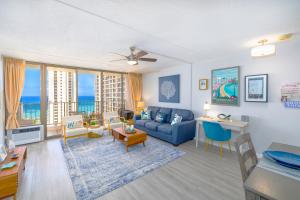 檀香山Waikiki Upscale 1 BR - Ocean Views - Parking的客厅配有蓝色的沙发和桌子