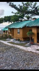 圣胡安海风海滨之家和度假小屋的海滩上一座带绿色屋顶的建筑