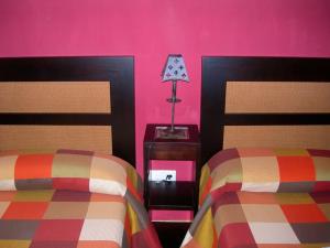 SotosalbosApartamento Rural en Sotosalbos的一间卧室设有两张床,墙壁粉红色