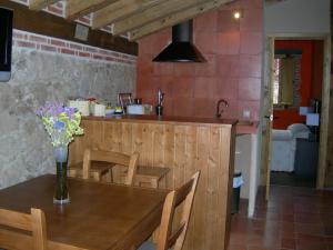 SotosalbosApartamento Rural en Sotosalbos的厨房配有带花瓶的木桌