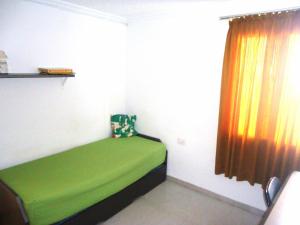 佩尼斯科拉El Trosset的小房间设有一张带窗户的绿色床