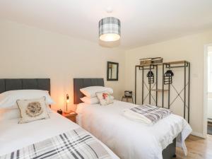 马姆斯伯里Orchard House Cottage的一间卧室配有两张带白色床单的床