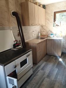 AndrijevicaKonak Mara- Komovi的厨房配有木制橱柜和炉灶烤箱。