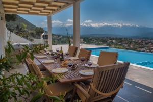 科基宁科里翁Villa Cassandra - A breathtaking view of Souda-Chania bay and the White Mountains的山景庭院内的餐桌