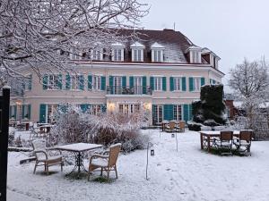蒙特勒伊蒙特里城堡酒店的一座大建筑,雪中摆放着桌椅