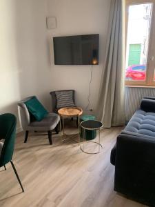 第戎Appartement velouté的客厅配有沙发、椅子和桌子