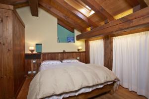 努斯Le Bibelot apartments的一间卧室配有一张带木墙的大床