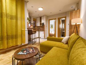 兹拉蒂博尔Kalman SPA&GYM的客厅配有绿色沙发和桌子