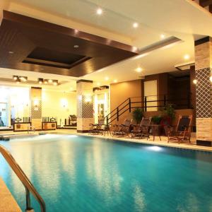 芭堤雅市中心KTK Pattaya Hotel & Residence的酒店的大型游泳池配有桌椅