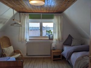 SugenheimSpatzennest und Rabennest的一间卧室设有一张床和一个窗口