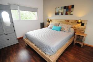 拉安戈斯图拉镇Departamento 22的一间卧室配有一张带蓝色枕头的木床。