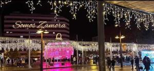 萨莫拉Casa De Paz的一群人在一个灯光明亮的购物中心前行走