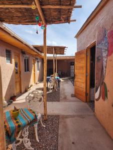 圣佩德罗·德·阿塔卡马Las Casas Hostel Atacama的一座建筑的一侧,设有长凳和壁画的庭院