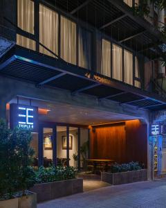 胡志明市Triple E Hotel Metro Ben Thanh的酒店入口前面设有桌子