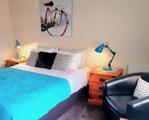 但尼丁Extended Stay City Hostel的卧室配有一张床和一把椅子,墙上有一辆自行车