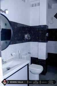 亭可马里Edwin Villa的一间带卫生间、水槽和镜子的浴室