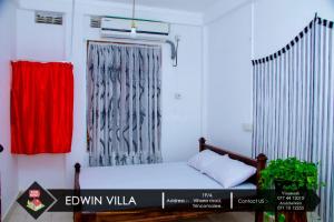 亭可马里Edwin Villa的小房间,配有床和窗帘